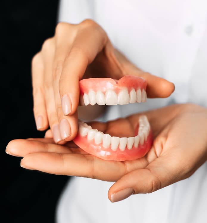 person holding a set of dentures